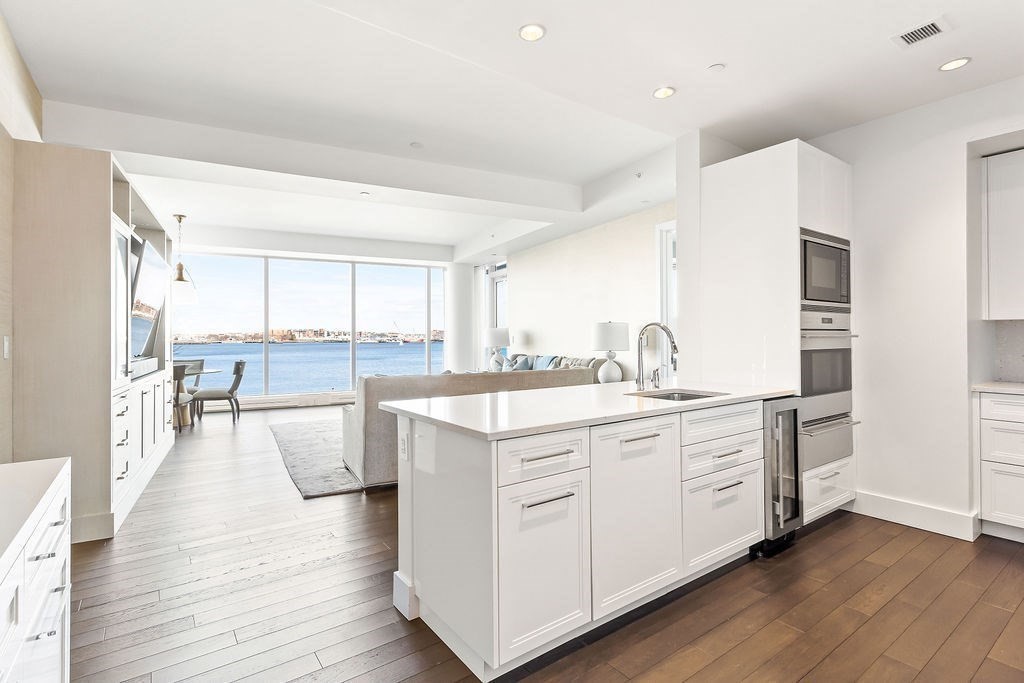 22 Liberty Drive, Unit 2F Boston, MA 02210 - Photo 9 of 28 a open kitchen with white cabinets and wooden floor