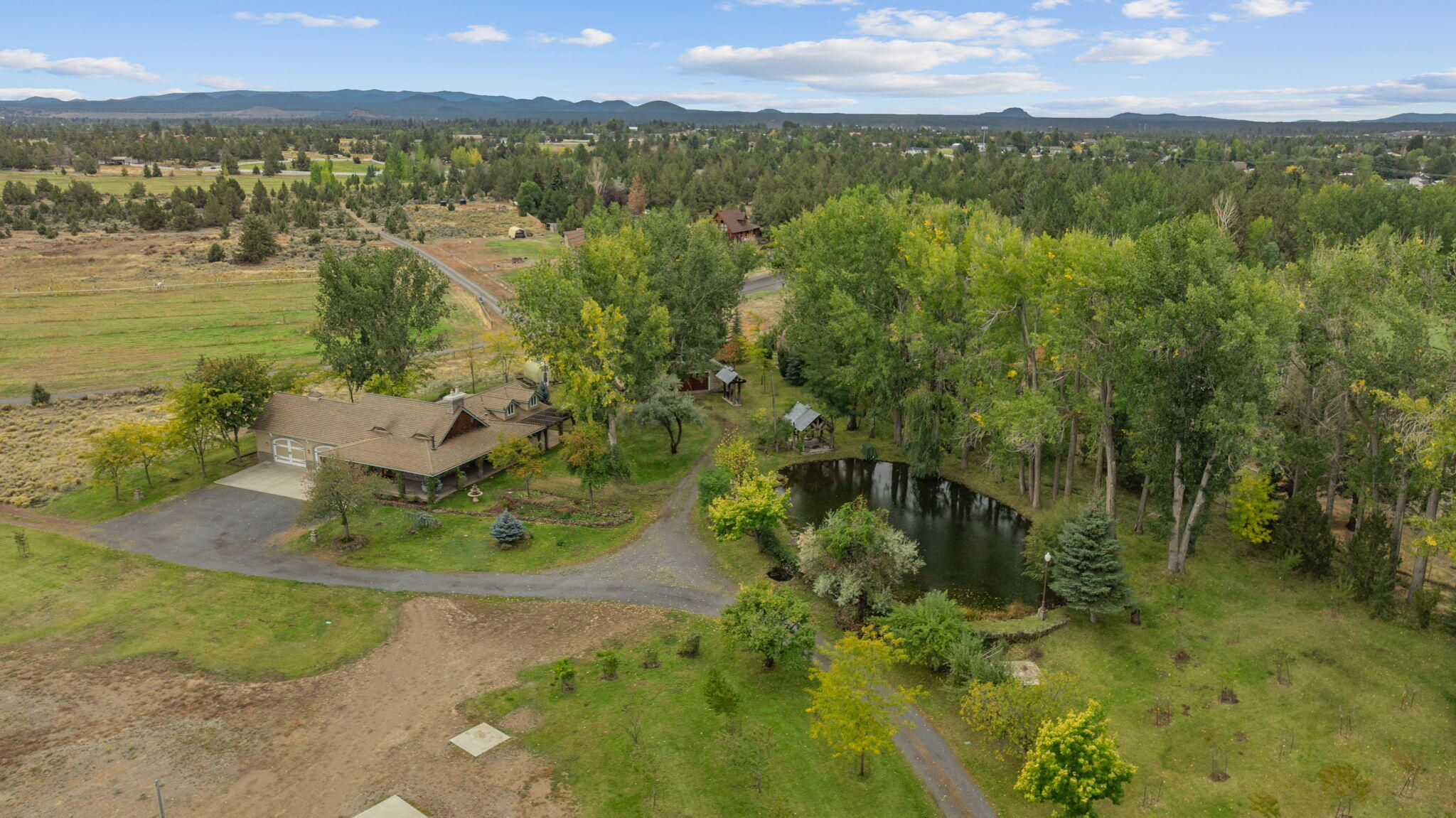 21925 Bear Creek Road Bend, OR 97702 - Photo 99 of 104 Arial photo of the house, shop, gazebo, upper pond and mature trees