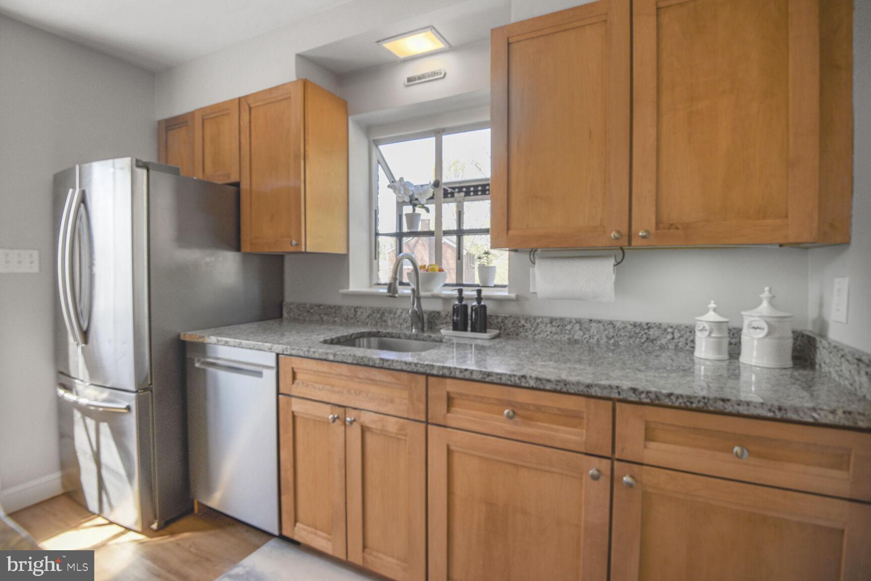 10002 Reddick Drive Silver Spring, MD 20901 - Photo 15 of 33 a kitchen with stainless steel appliances granite countertop a sink a refrigerator and a granite counter tops