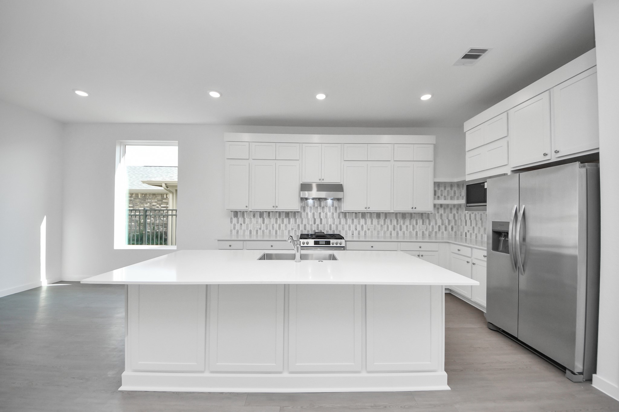 27111 Blue Pool Drive Katy, TX 77493 - Photo 12 of 38 a large kitchen with stainless steel appliances a large counter top a stove and a refrigerator