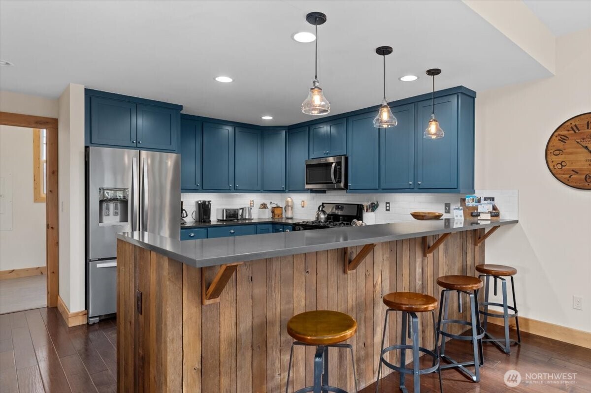 108 Jackrabbit Lane Chelan, WA 98816 - Photo 14 of 40 a kitchen with kitchen island granite countertop a sink a stove a refrigerator and chairs