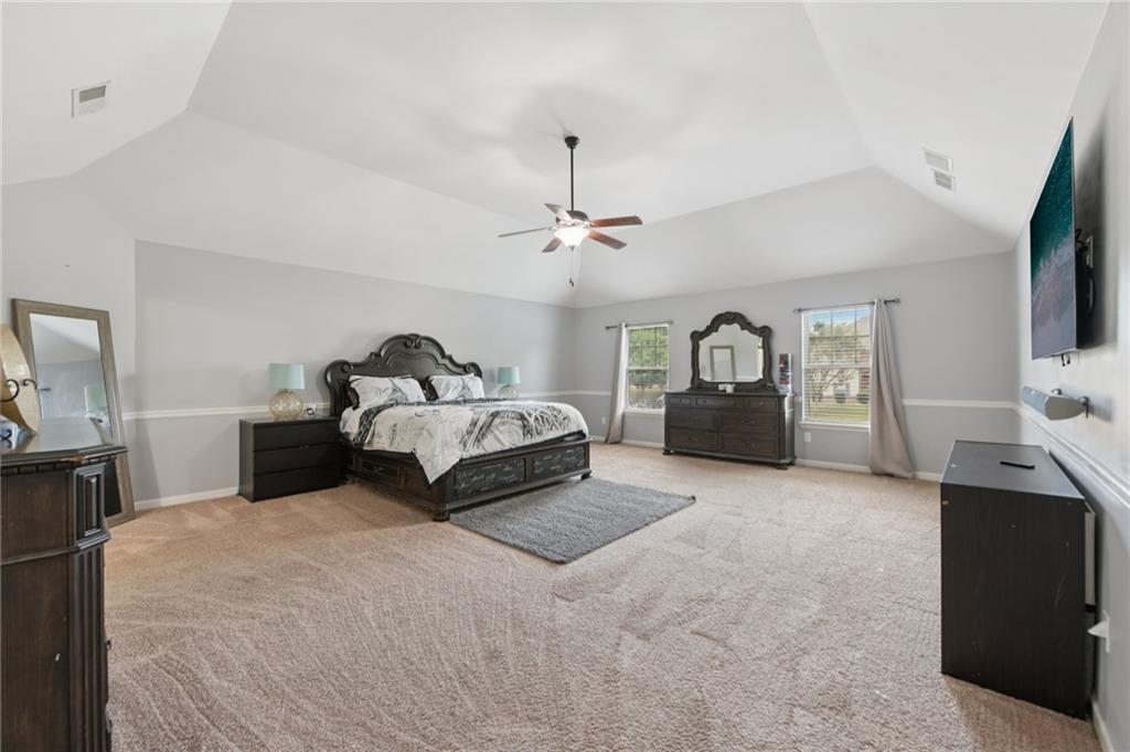 115 Tanners Court Covington, GA 30016 - Photo 37 of 60 a spacious bedroom with a bed and a flat tv screen on dresser