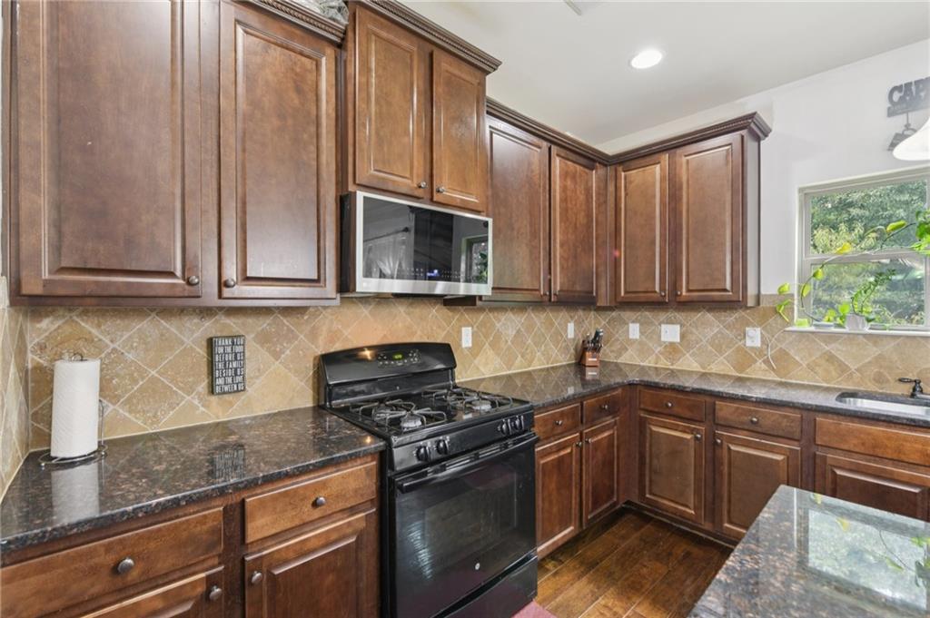 115 Tanners Court Covington, GA 30016 - Photo 41 of 60 a kitchen with stainless steel appliances granite countertop a sink a stove a microwave and cabinets