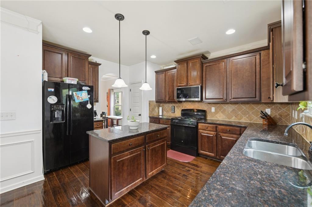 115 Tanners Court Covington, GA 30016 - Photo 45 of 60 a kitchen with stainless steel appliances granite countertop a sink a stove and a refrigerator