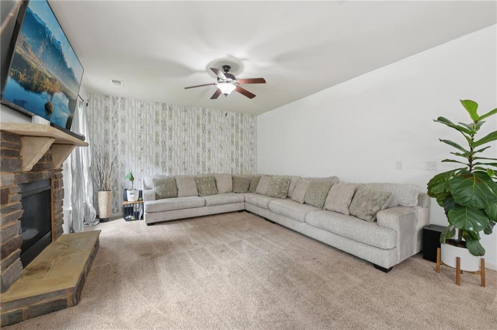 115 Tanners Court Covington, GA 30016 - Photo 55 of 60 a living room with furniture a fireplace and a potted plant