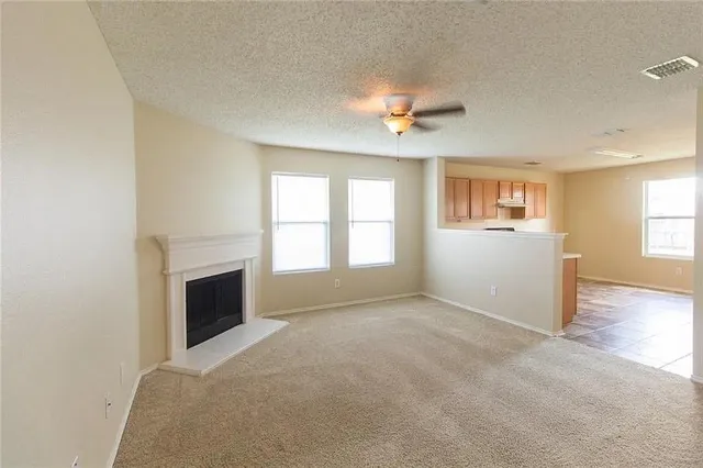 a view of an empty room with a fireplace and a window