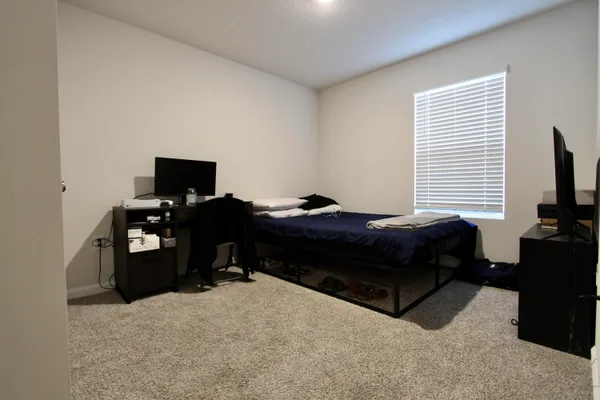 a bedroom with a bed and a flat screen tv