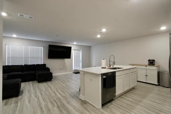 a living room with a sink and a flat screen tv