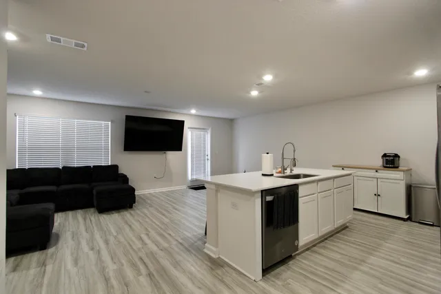 a living room with a sink and a flat screen tv