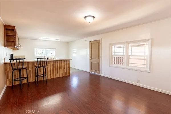 a view of a kitchen with furniture and wooden floor