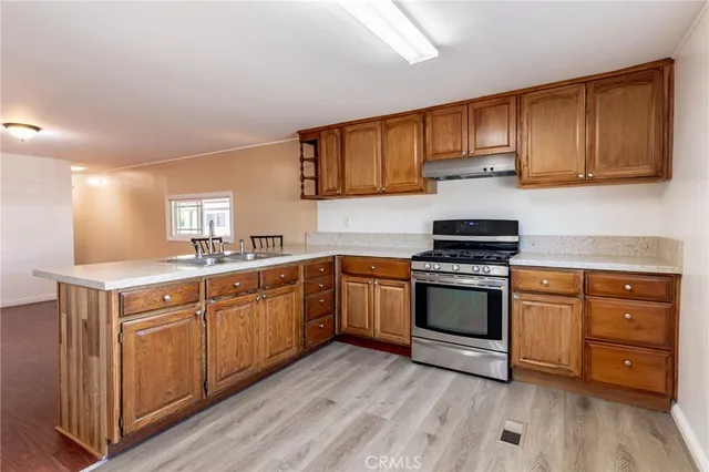 a kitchen with stainless steel appliances granite countertop a stove cabinets and wooden floor