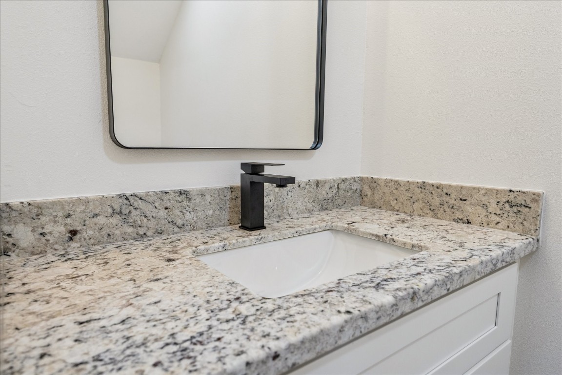 9913 Porto Rico Road Houston, TX 77041 - Photo 23 of 34 a bathroom with a granite countertop sink and a mirror