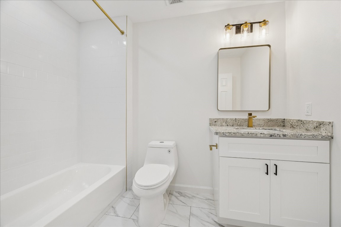 9913 Porto Rico Road Houston, TX 77041 - Photo 31 of 34 a bathroom with a granite countertop toilet a sink and bathtub