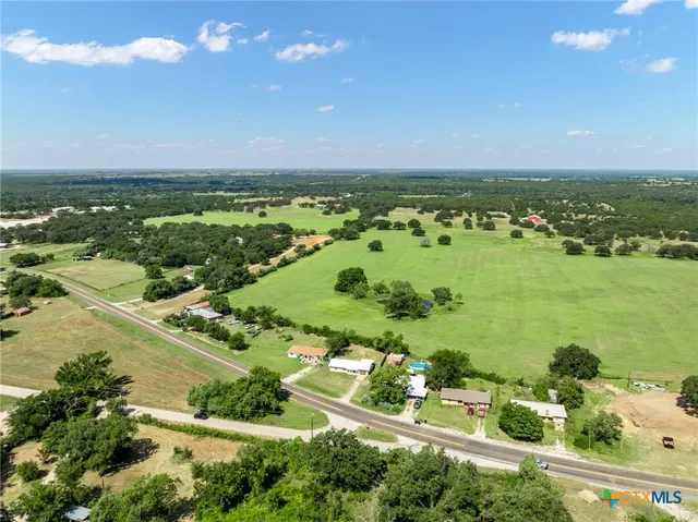 an aerial view of ocean and residential houses with outdoor space