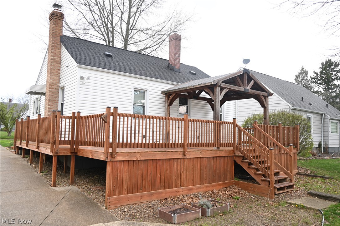 94 North 5th Street Rittman, OH 44270 - Photo 24 of 27 Rear view of house featuring a chimney, a wooden deck, a gazebo, a shingled roof, and a garden