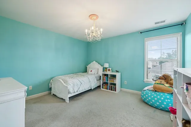 a bedroom with a bed and a chandelier