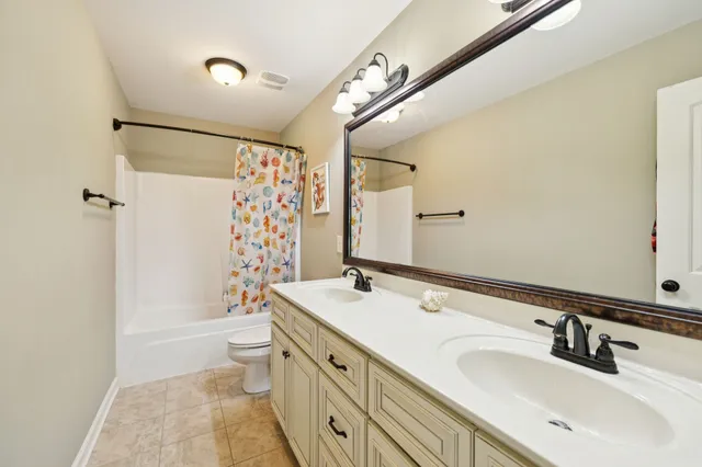a bathroom with a double vanity sink toilet mirror and shower