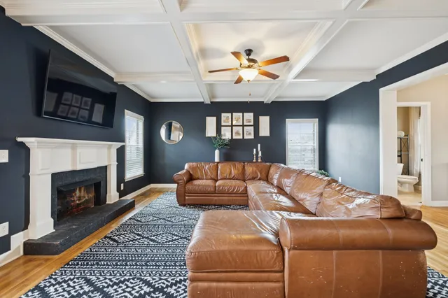 a living room with a couch wooden floor and a fireplace