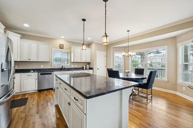 a kitchen with a stove a sink a counter space and wooden floor