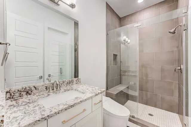 a bathroom with a granite countertop sink toilet and shower