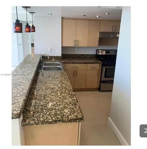 a kitchen with kitchen island sink stove and cabinets