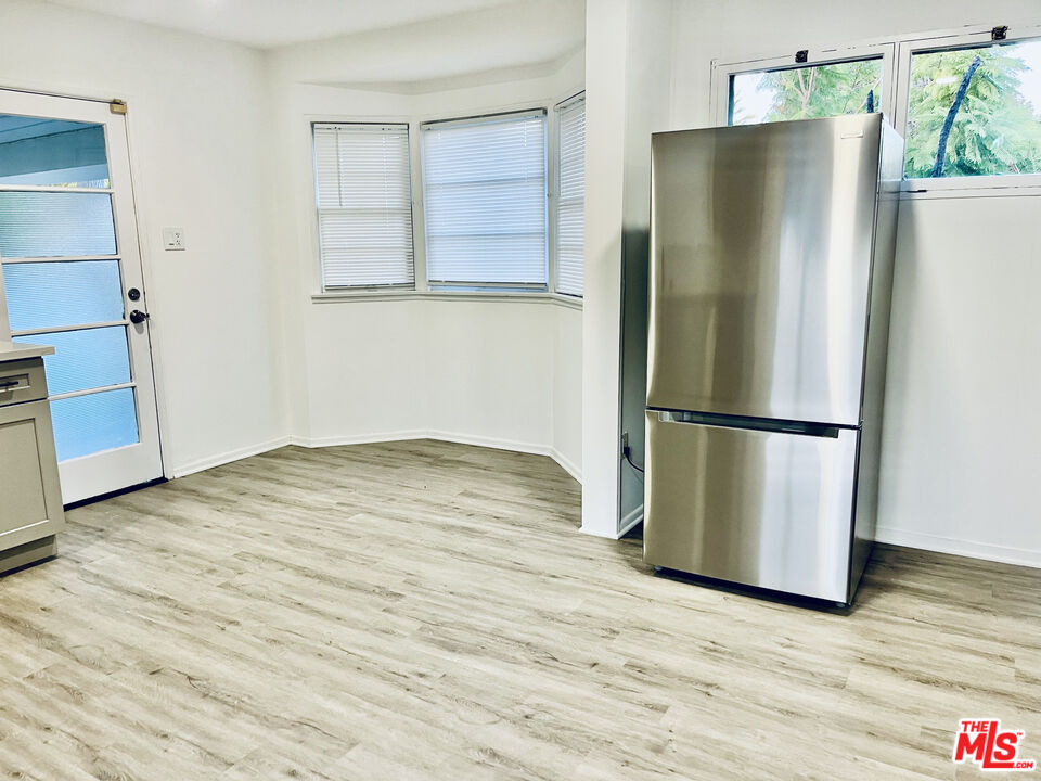4675 Laurelgrove Avenue Studio City, CA 91604 - Photo 6 of 15 a room with wooden floor and a refrigerator