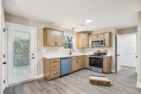 a kitchen with stainless steel appliances granite countertop a stove a sink and a refrigerator