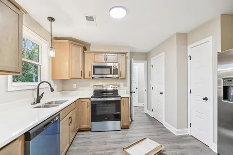 a kitchen with stainless steel appliances granite countertop a sink stove and refrigerator