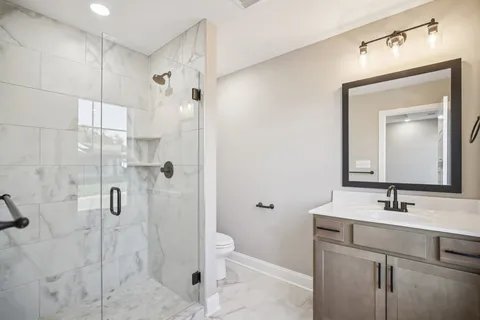 a bathroom with a sink a toilet and shower