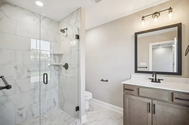 a bathroom with a sink a toilet and shower