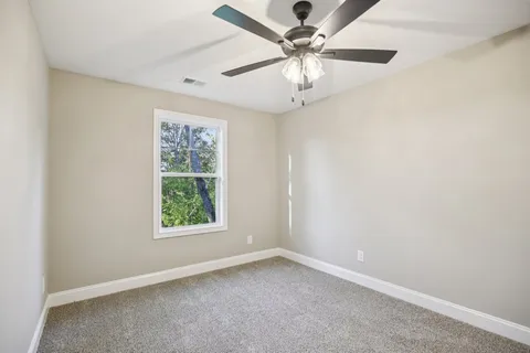 an empty room with a window and a fan