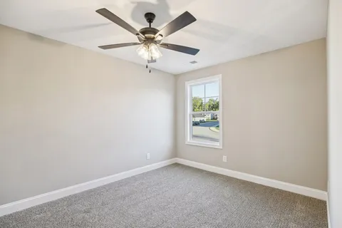 an empty room with a window and a fan