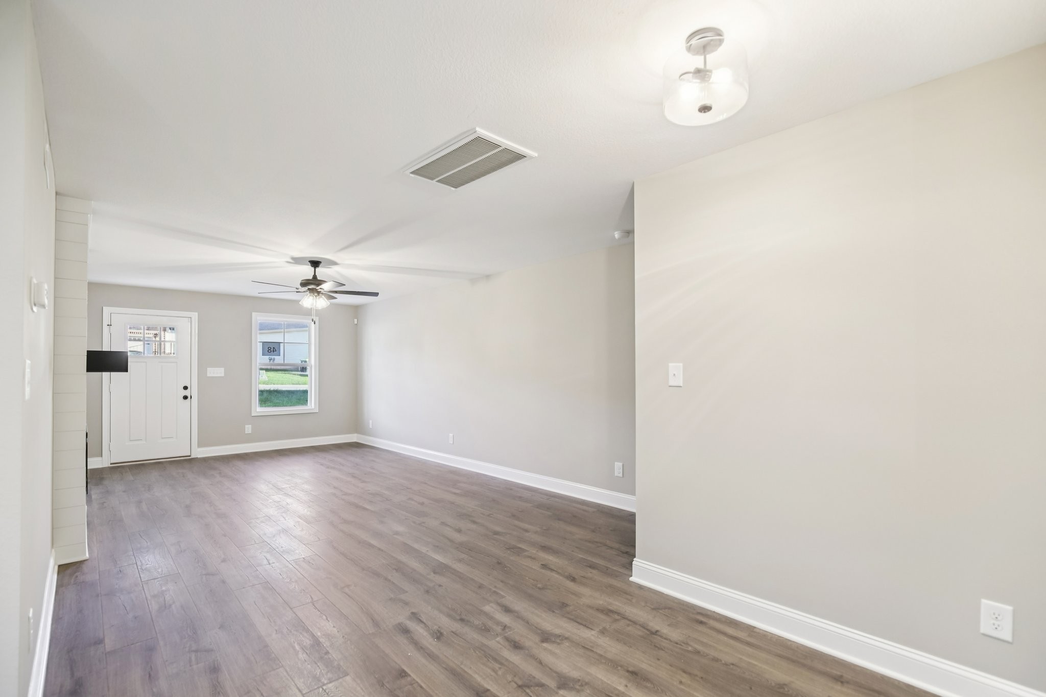 1288 Racker Drive Clarksville, TN 37043 - Photo 8 of 49 an empty room with wooden floor chandelier fan and windows