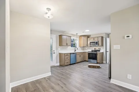 a large kitchen with a wooden floor and a large window