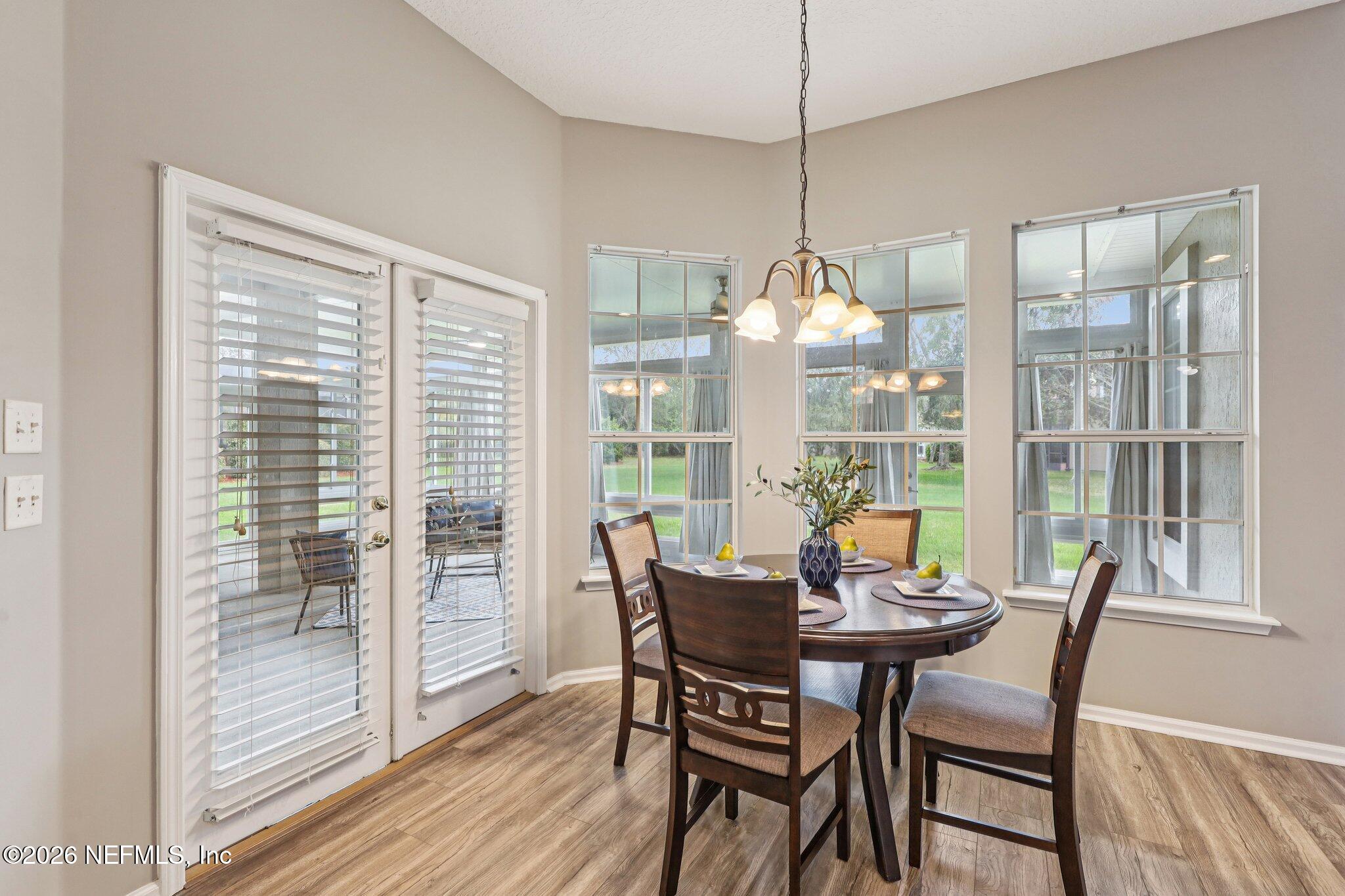 1933 Summit Ridge Road Fleming Island, FL 32003 - Photo 16 of 59 a dining room with furniture large windows and wooden floor