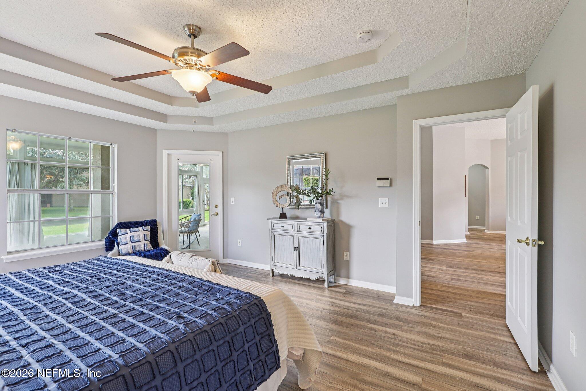 1933 Summit Ridge Road Fleming Island, FL 32003 - Photo 22 of 59 a bedroom with a large bed and a chandelier