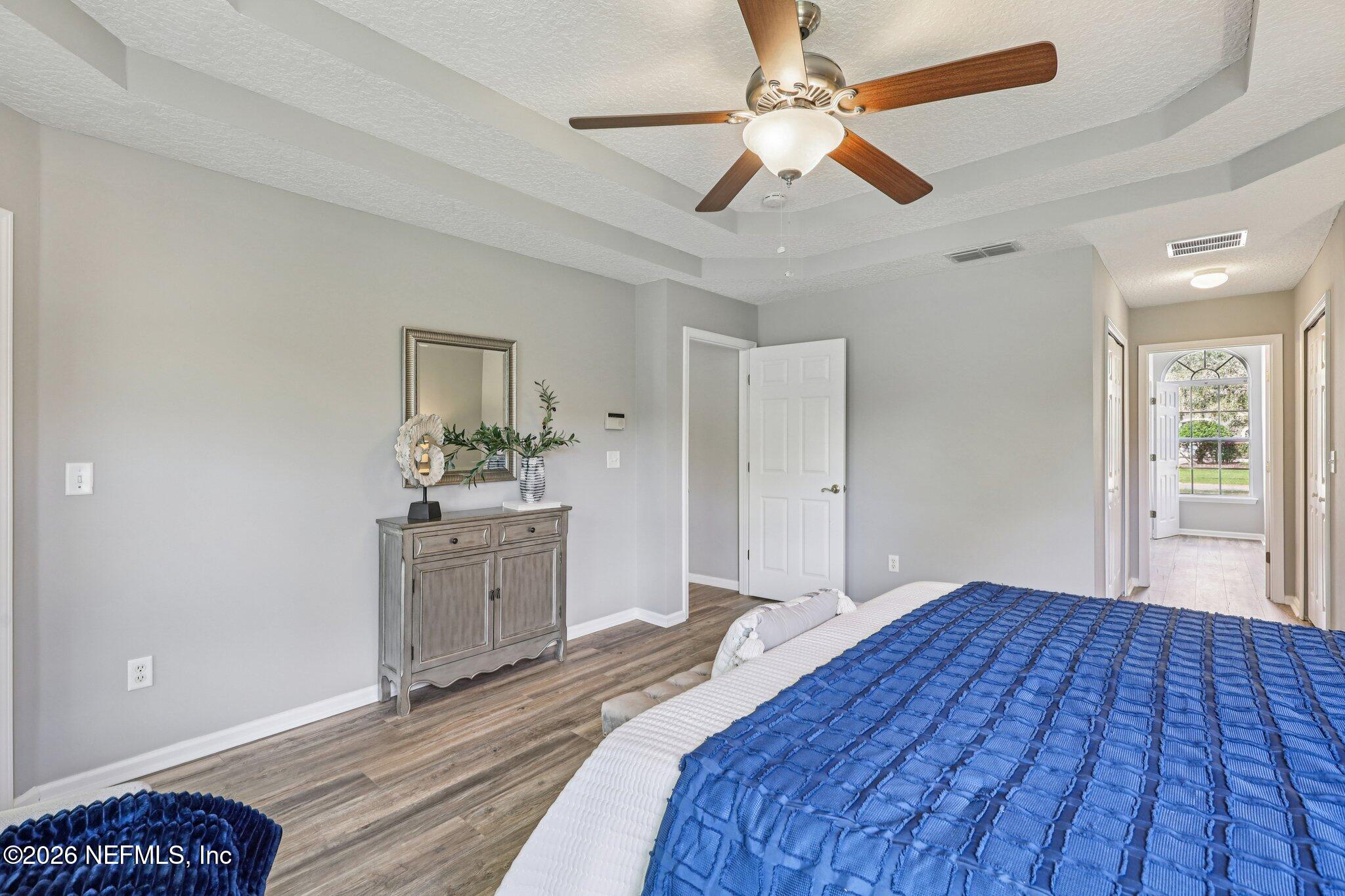 1933 Summit Ridge Road Fleming Island, FL 32003 - Photo 26 of 59 a bedroom with a bed and a chandelier