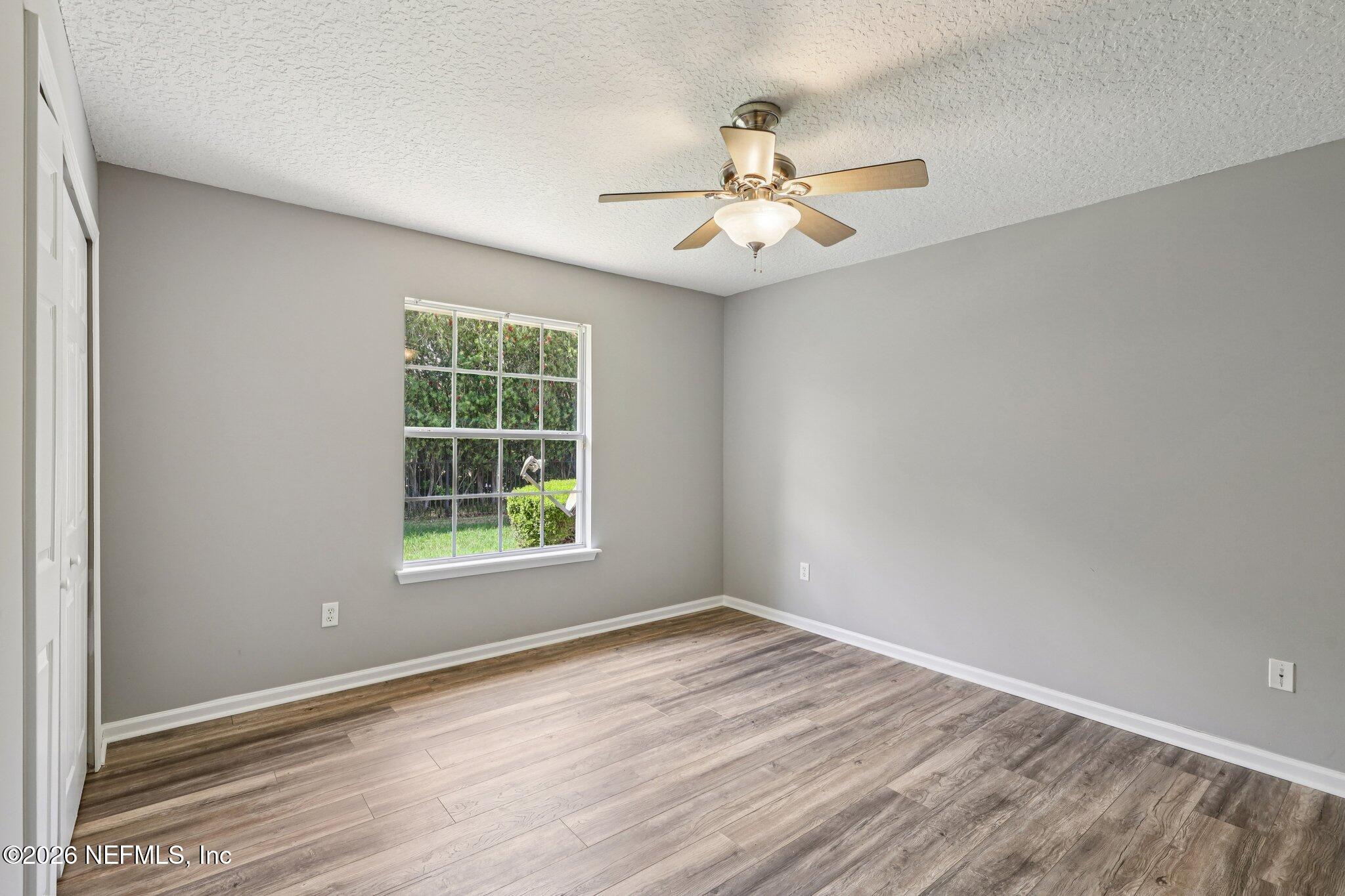 1933 Summit Ridge Road Fleming Island, FL 32003 - Photo 32 of 59 an empty room with wooden floor fan and windows