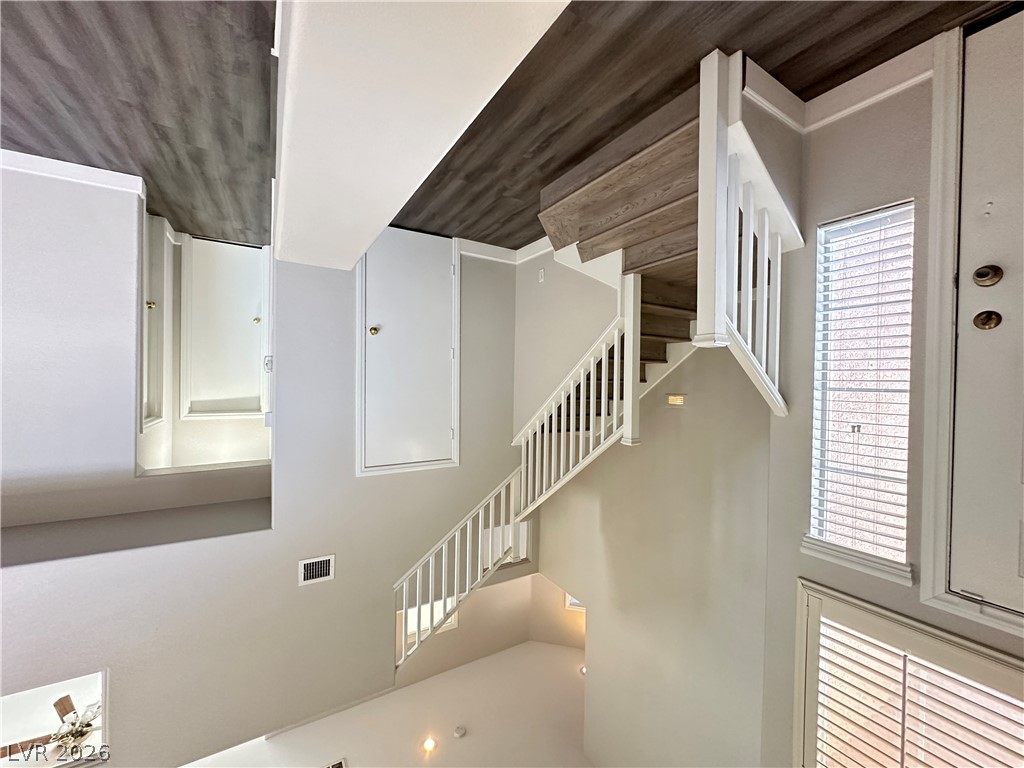 10191 Splendor Ridge Avenue Las Vegas, NV 89135 - Photo 12 of 31 Elegant wooden staircase connects levels, featuring classic white balusters and rich wood treads.