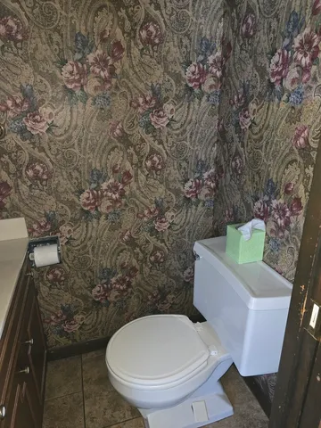 a view of an empty room with wooden floor and a cabinet