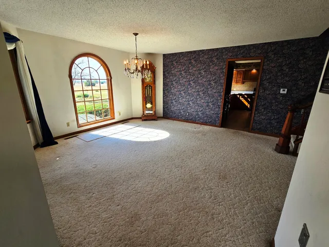 a view of an empty room with a fireplace and a window