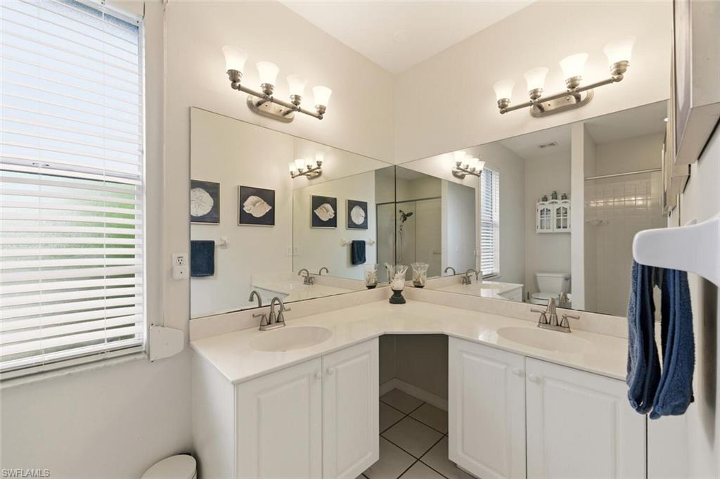 157 Versailles Circle Naples, FL 34112 - Photo 18 of 36 a bathroom with a sink vanity and a mirror