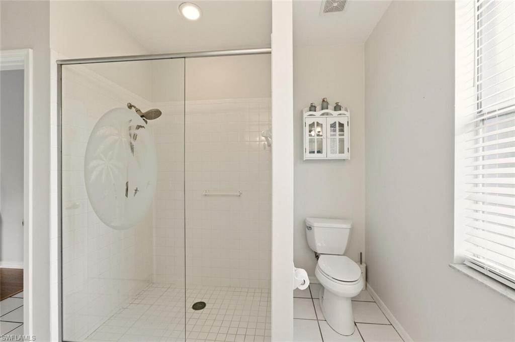 157 Versailles Circle Naples, FL 34112 - Photo 19 of 36 a bathroom with a toilet and a shower