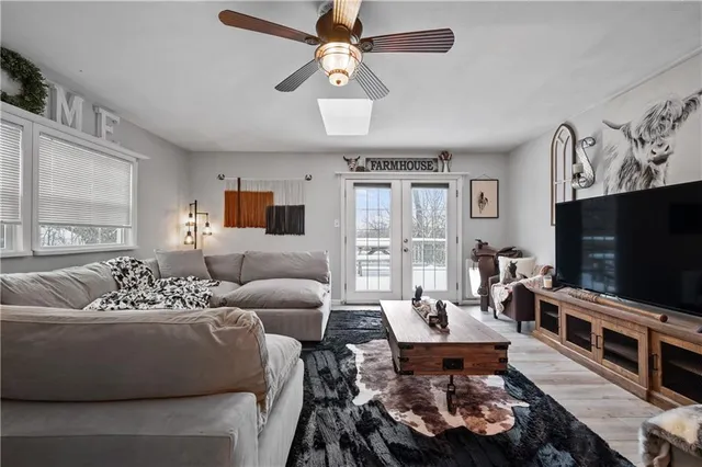 a living room with furniture a chandelier and a window
