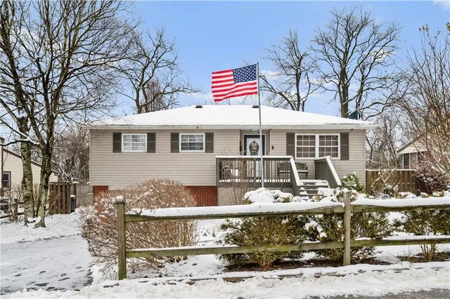 a front view of a building with large trees