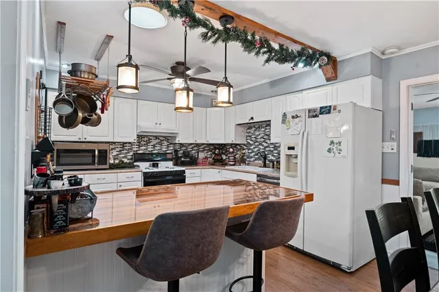 a room with stainless steel appliances kitchen island granite countertop furniture and a view of kitchen