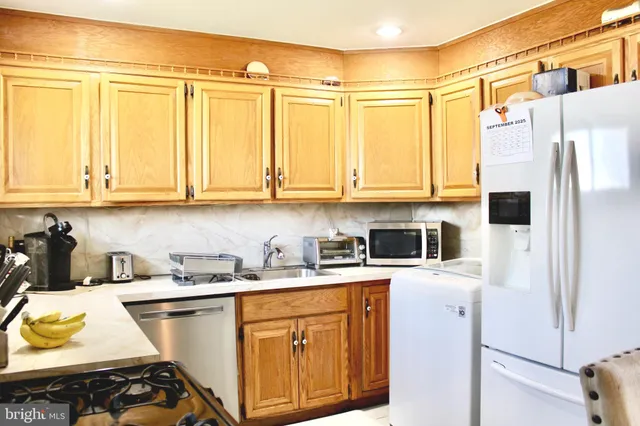 a kitchen with a sink a refrigerator and cabinets