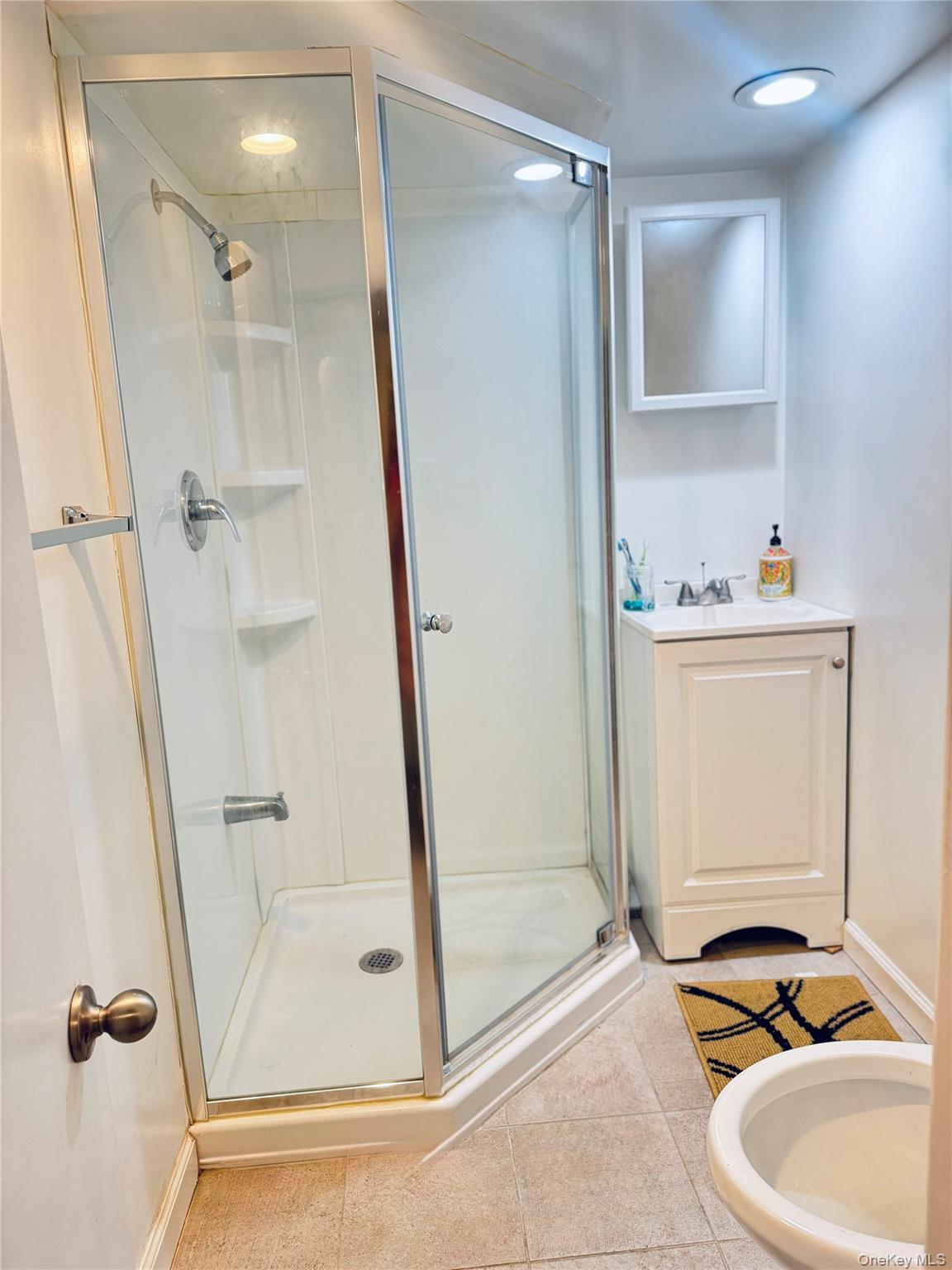 86-29 90th Street Queens, NY 11421 - Photo 8 of 14 Bathroom with a stall shower, vanity, and light tile patterned floors