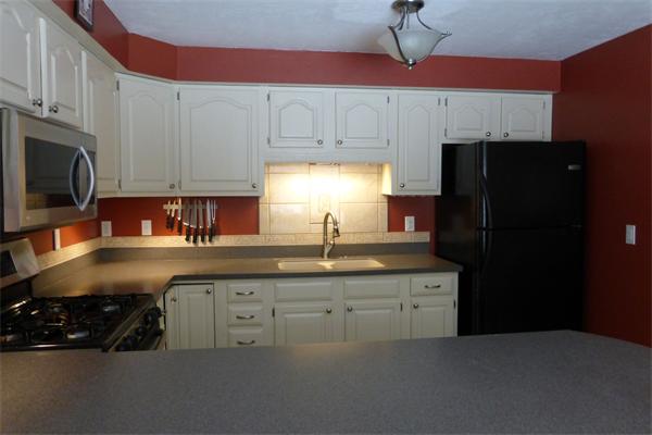 183 Beaman Road Sterling, MA 01564 - Photo 6 of 15 a kitchen with stainless steel appliances a sink cabinets and a refrigerator