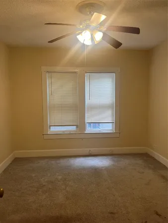an empty room with wooden floor mirror and windows